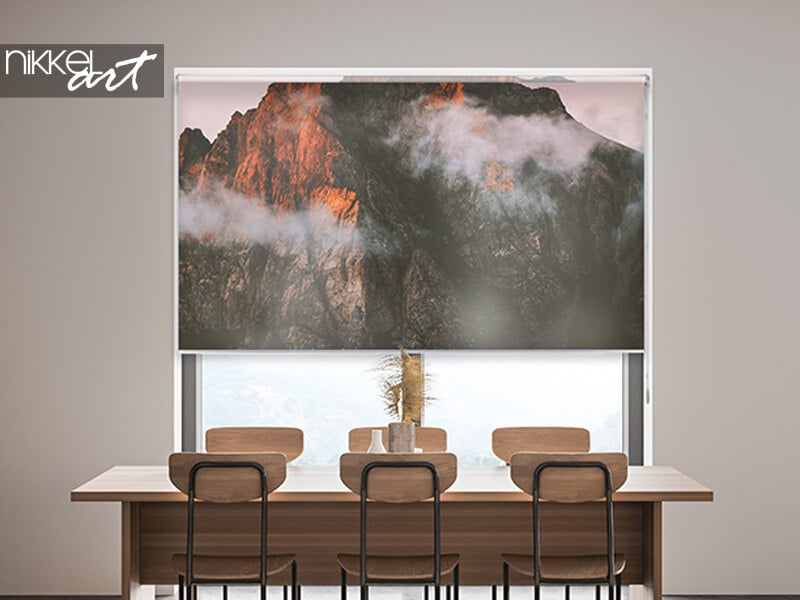 Store enrouleur à motif de montagne au-dessus d'une table, cassette visible en haut