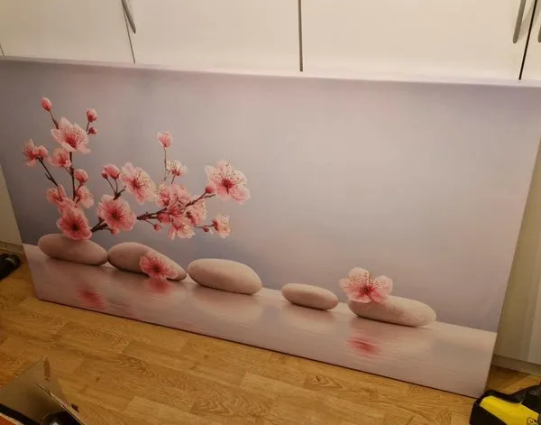 Tableau sur toile Tableau sur toile Fleurs de cerisier roses disposées sur des pierres blanches sur fond bleu — inspiration de clients